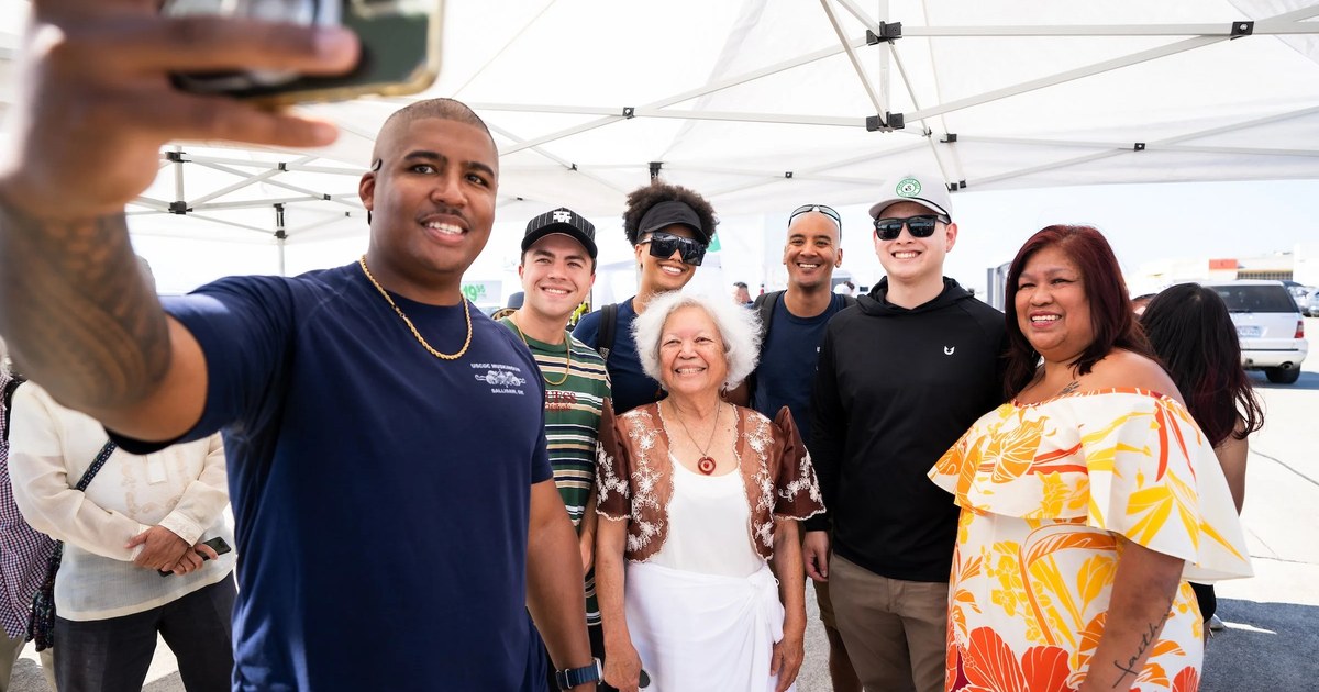 A group of attendees takes a selfie together under a tent at Filipino Island Fest at Alameda Point in 2024